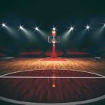 Courtline Clash Triggers SHOCK Arena Ban Basketball hoop on an empty indoor court under bright arena lights