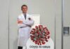 Cardboard cutout of doctor with COVID-19 virus info display