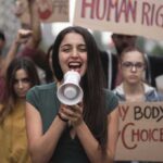 Young woman leading a protest with a megaphone