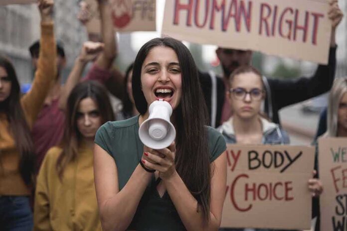 Young woman leading a protest with a megaphone