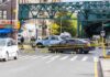 Police cars block a city intersection with yellow crime scene tape