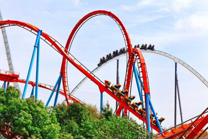 Roller,Coaster,In,Funny,Amusement,Park. Colorful roller coaster with riders on a sunny day