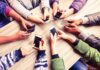 Hands around a table holding smartphones