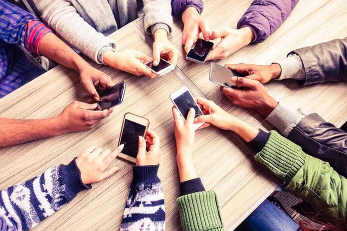 Hands around a table holding smartphones