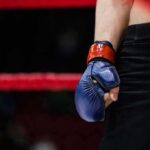 Boxer with blue glove standing by the ropes