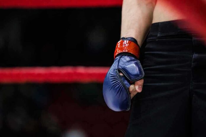 shutterstock_401198332-6 Boxer with blue glove standing by the ropes
