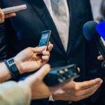 Cuban Targets Big Medicine Cartel businessperson in suit surrounded by microphones and recorders