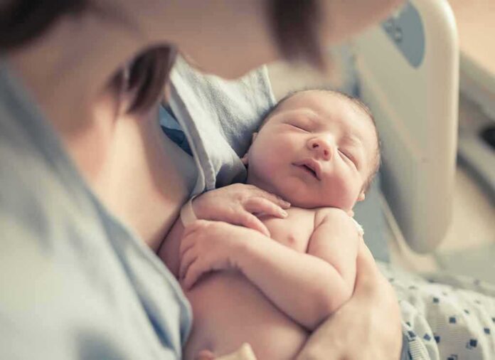 shutterstock_663728050-6 newborn baby sleeping in a parent's arms