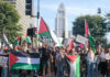 Protesters holding Palestinian flags gather in a city street