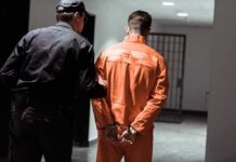 School Scandal Triggers Fast Removal Police officer escorting handcuffed inmate in orange jumpsuit
