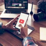 100 Practice Plays Triggered An NFL War Hands holding smartphone with video app icon at a workspace