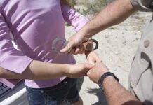 Mother Charged After Child Dies At Home Officer placing handcuffs on a person's wrists