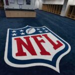 NFL Shock: Aldon Smith Gone at 36 NFL logo on the floor of an empty locker room
