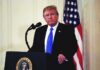 Why Trump Chose The Pentagon For 9/11 man at podium with microphone and US flag
