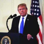 Why Trump Chose The Pentagon For 9/11 man at podium with microphone and US flag