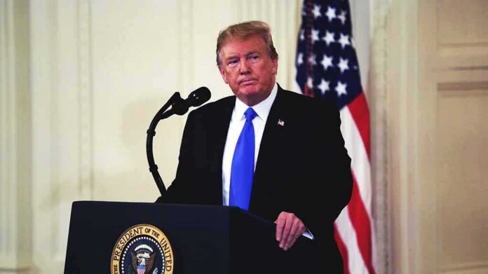 shutterstock_1326218579-2 man at podium with microphone and US flag