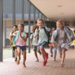 Group of schoolchildren running down a hallway