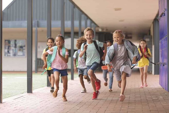 Group of schoolchildren running down a hallway