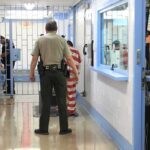 ICE Warrants Face A Constitutional Home Barrier Corrections officers escort an inmate in a jail hallway