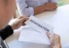 Person handing over a resignation letter in an envelope