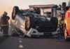 SUV Swept Away in Sudden Mudflow Overturned car on road with firefighters and ambulance
