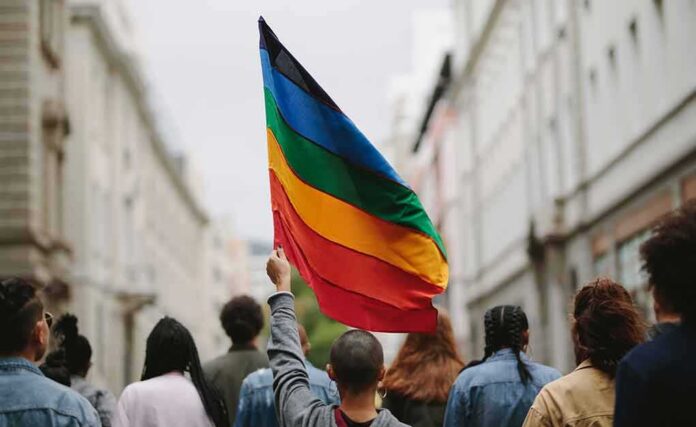 Person holding a rainbow flag in a city street march