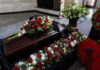 Harlem Mourns Woman Killed At Home Coffin with floral arrangements at a funeral service