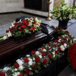 Coffin with floral arrangements at a funeral service