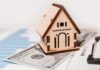 Wooden house model on money and contract papers