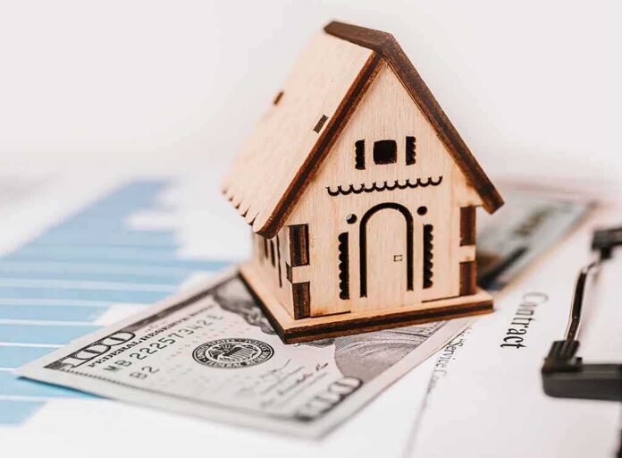 shutterstock_1899778699-12 Wooden house model on money and contract papers