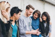 Off-Campus Greek Life’s Deadliest Trap Group of friends looking at a smartphone