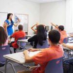 Activist Admits Years-Long Identity Deception Teacher leading classroom discussion with students raising hands