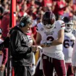 38 QBs Played As Starters Fell Mississippi State football coach and quarterback review play card on sideline