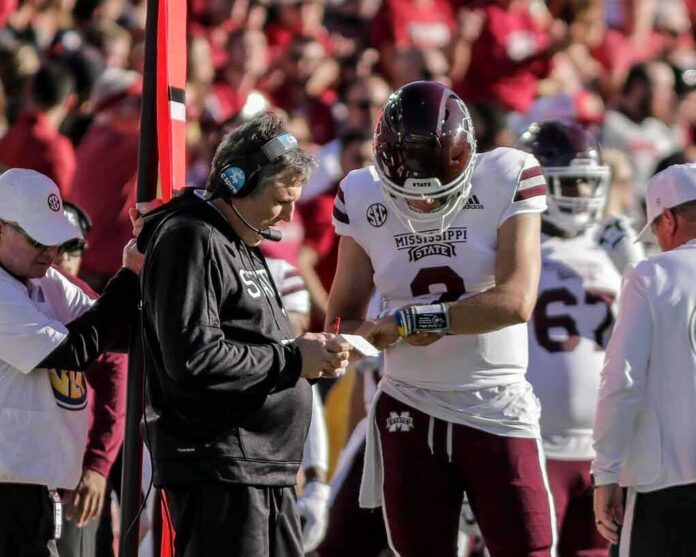 shutterstock_2070833297-4 Mississippi State football coach and quarterback review play card on sideline