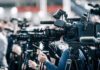 Judge Slaps Down Dismissal Bid Broadcast cameras on tripods at a press event