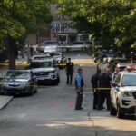 Does Immigration Status Change Crime Policy? Police officers secure a residential street with patrol cars and yellow tape