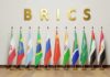 BRICS letters above a row of national flags on stands