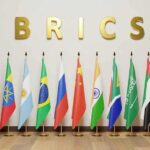 BRICS letters above a row of national flags on stands