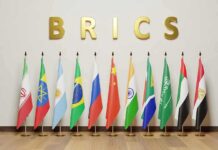 BRICS Ditches Hype, Rewires Money Pipes BRICS letters above a row of national flags on stands