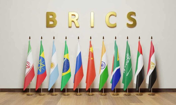 shutterstock_2367924823-4 BRICS letters above a row of national flags on stands