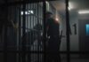 Dangerous Detainee Release Sparks Legal Questions police officer at a jail cell with detainees behind bars