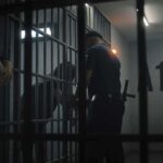 Dangerous Detainee Release Sparks Legal Questions police officer at a jail cell with detainees behind bars