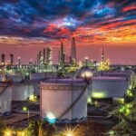Oil refinery with storage tanks at sunset