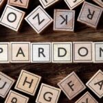 Pardon Brokers Promise Access For Millions Wooden letter blocks arranged to spell 'PARDON' on a wooden surface