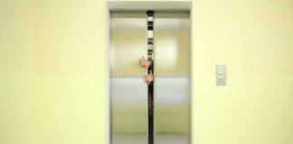 Elevator doors closing with hands reaching through the gap