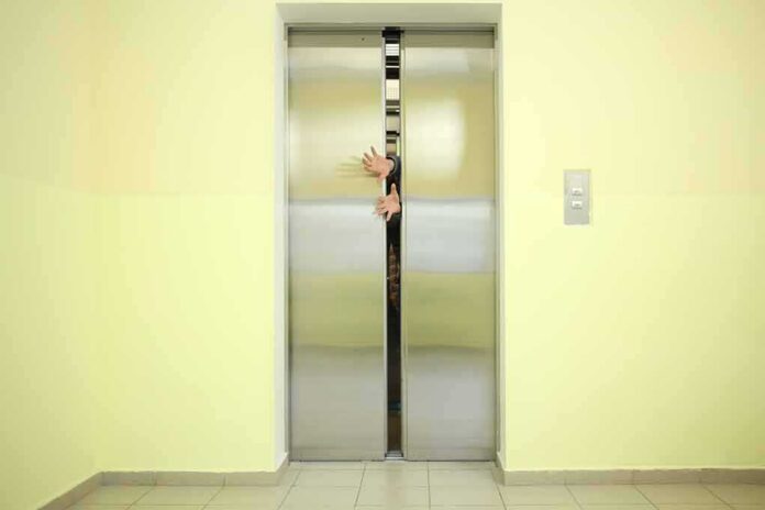 Elevator doors closing with hands reaching through the gap
