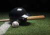 Baseball helmet, bat, and ball on artificial turf