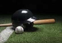 Baseball helmet, bat, and ball on artificial turf
