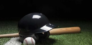 Baseball helmet, bat, and ball on artificial turf