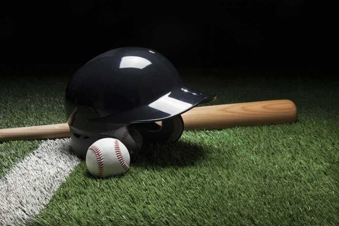 shutterstock_647152357 Baseball helmet, bat, and ball on artificial turf